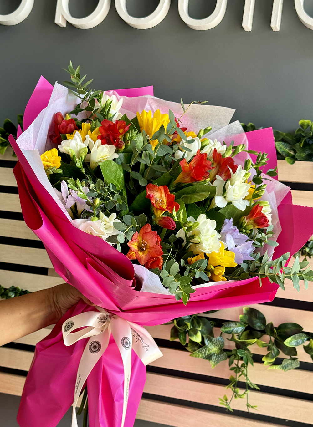 Buchet Parfum cu frezii multicolore și salal, ambalat în hârtie roz – livrare flori Iași azalee.ro