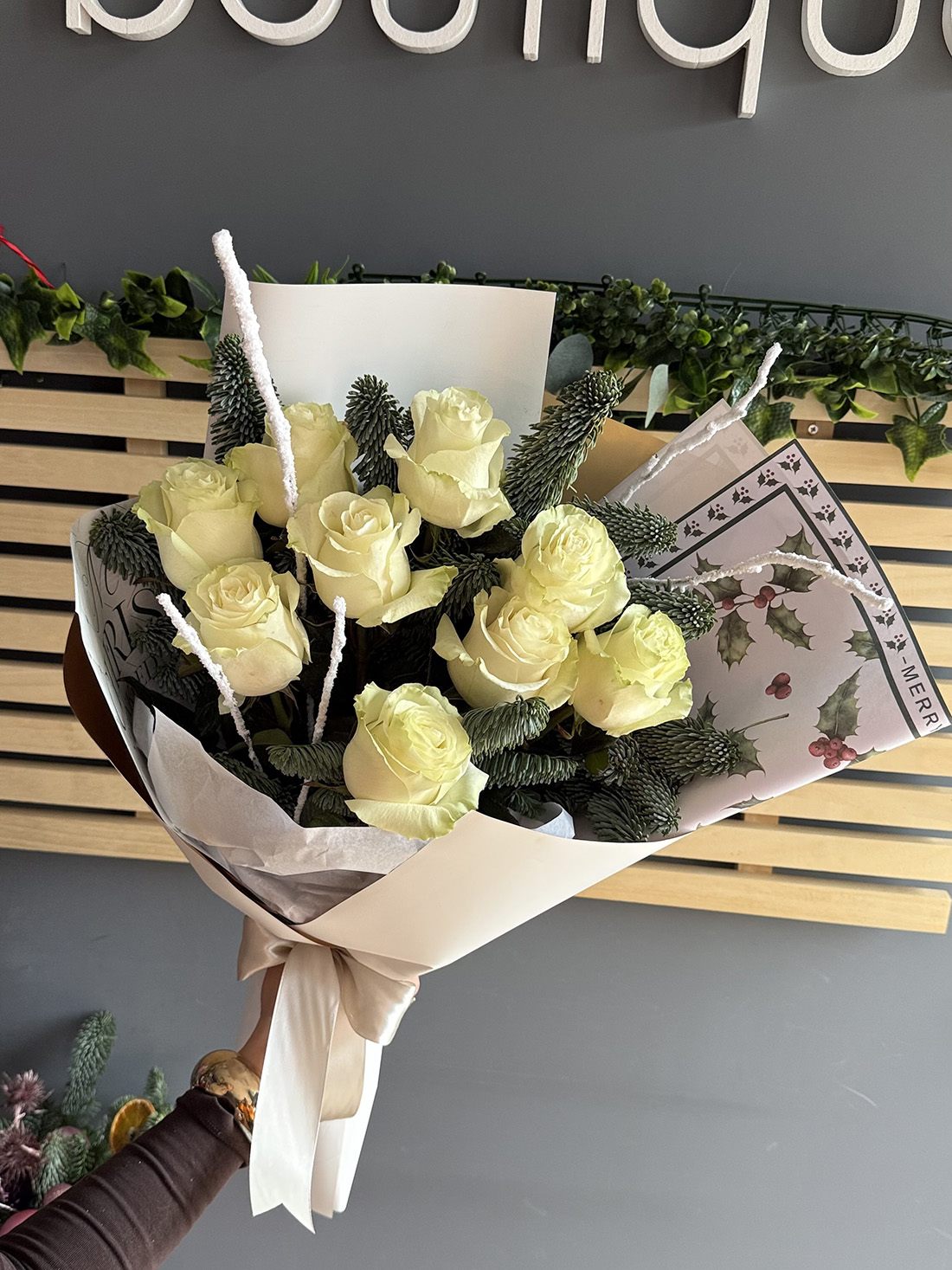 Buchet White Christmas cu trandafiri albi și crenguțe de brad în ambalaj crem, livrare flori Iași.