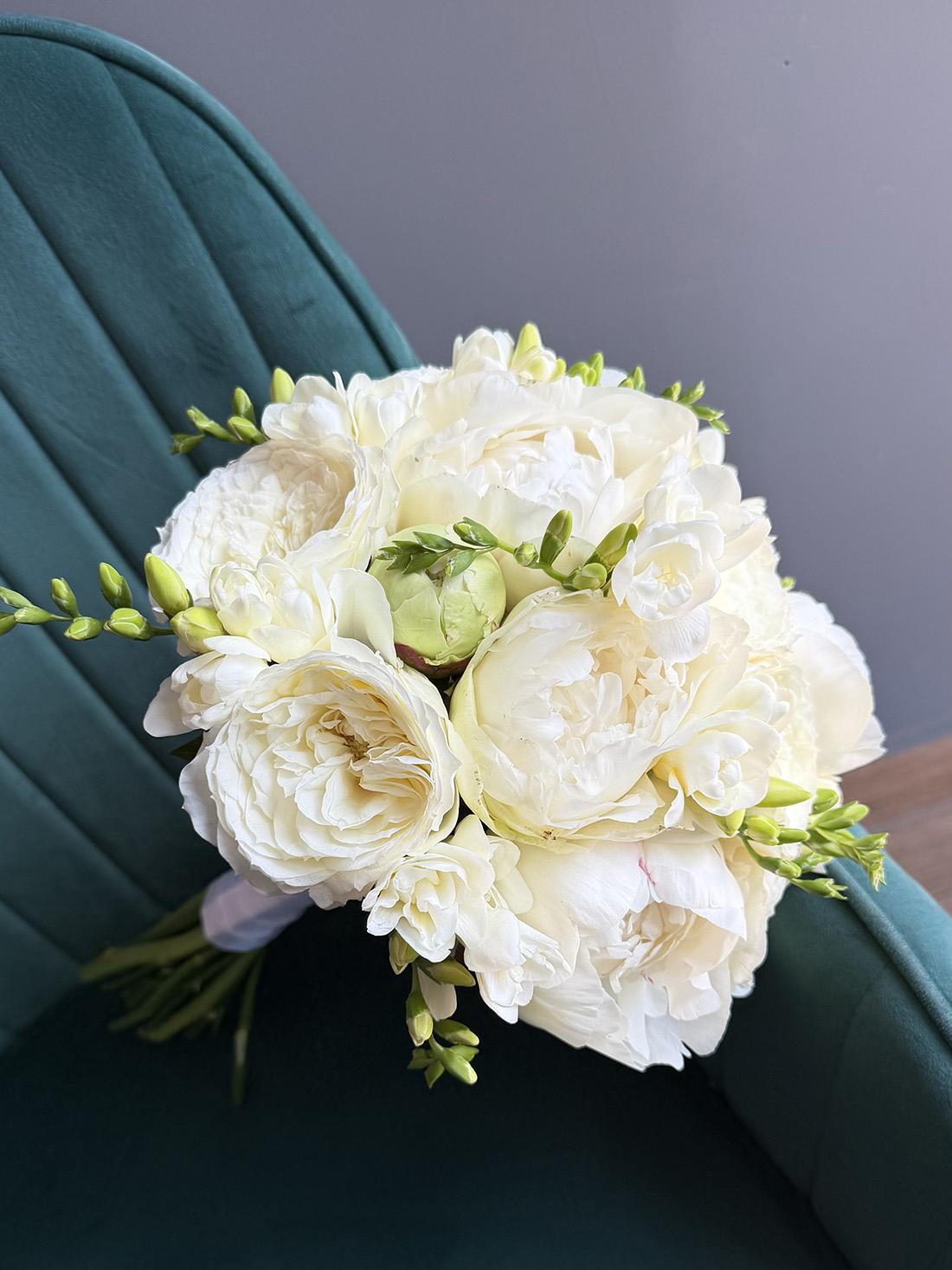Buchet de mireasă Bianca Sposa rotund cu bujori albi, trandafiri de grădină și frezii, cu mâner finalizat cu panglică