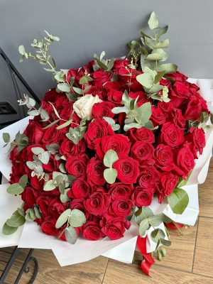 Buchet One in a Million cu 100 trandafiri roșii și 1 trandafir alb central, completați cu eucalipt, în ambalaj alb