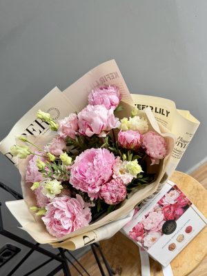 Pachet Pivoine & Praline cu bujori roz, eustoma și cutie cu 9 trufe Pure Chocolate în ambalaj tip newspaper